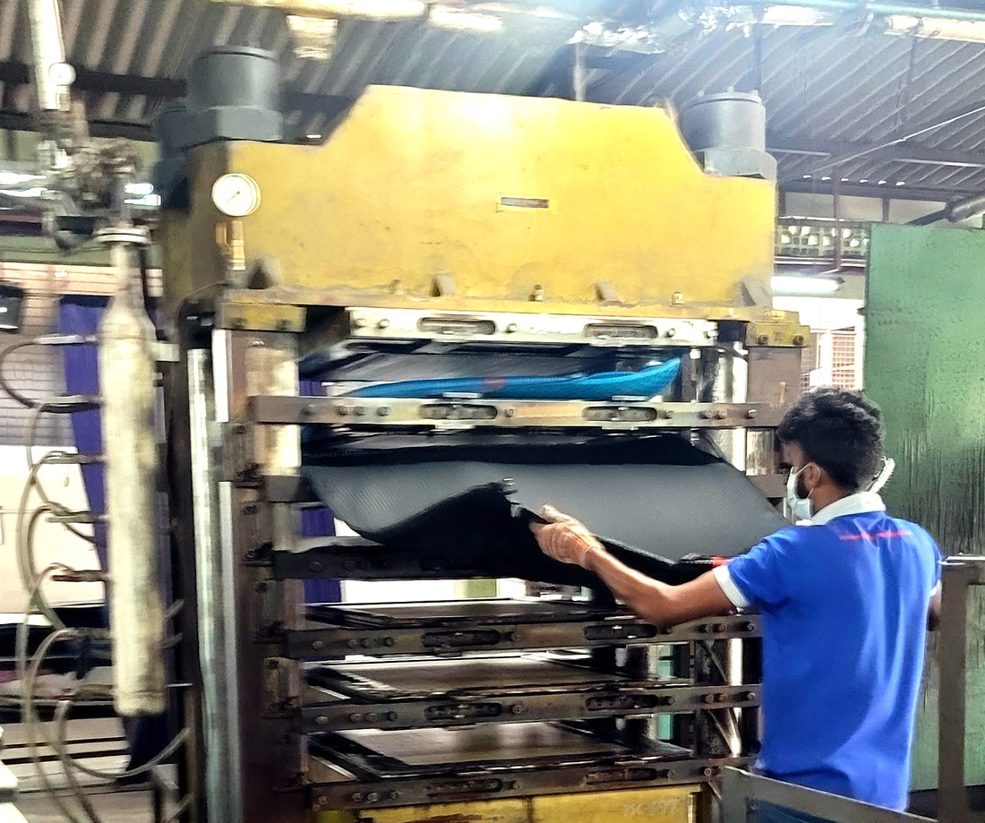 Operator loading an EVA sheet into the multi-layer press