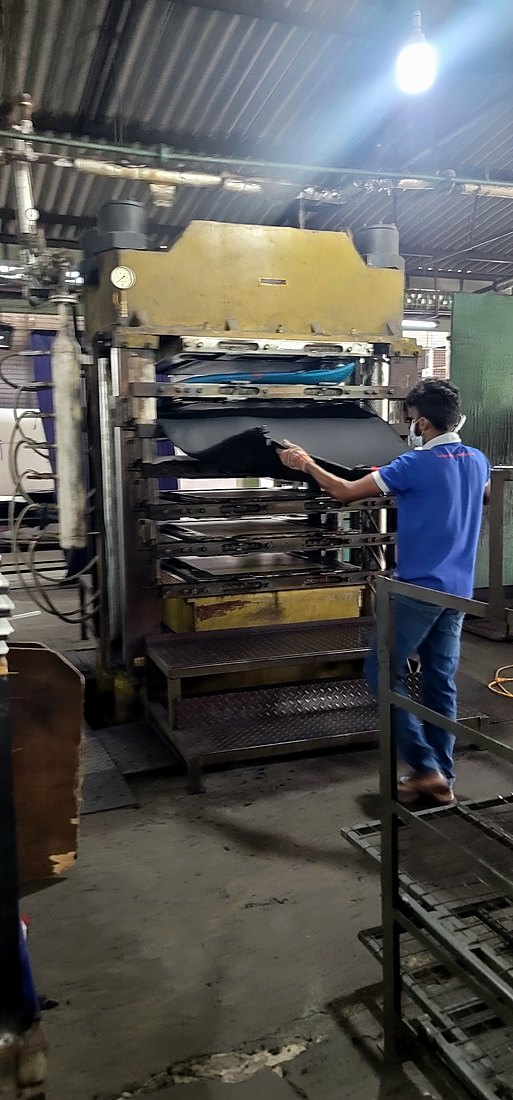 Operator removing an EVA sheet from a hydraulic press