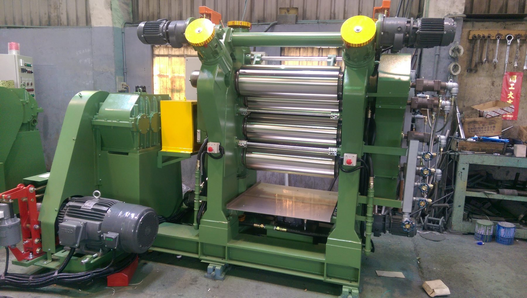 Four-roll sheeting machine with drive motor, gearbox and take-off tray